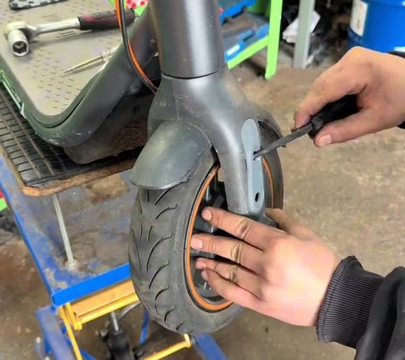 Schraubenkontrolle am Vorderrad eines E-Scooters